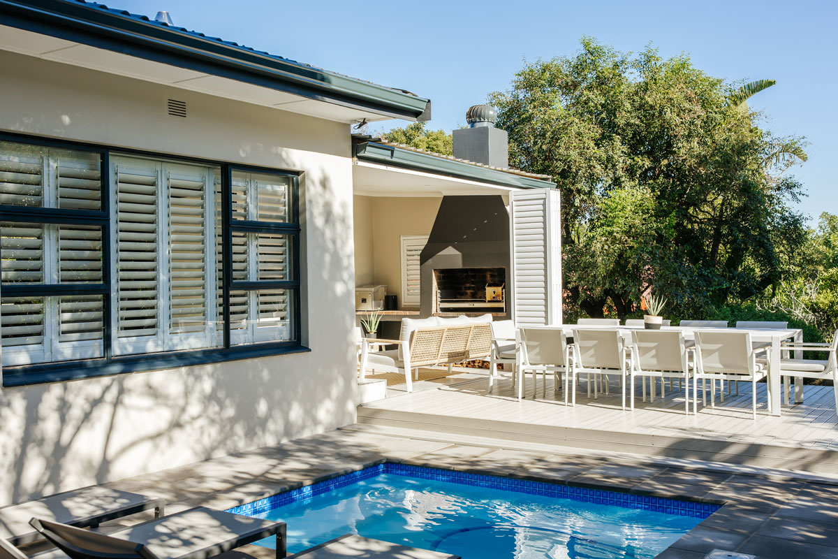Charcoal shutters on a home beside a swimming pool