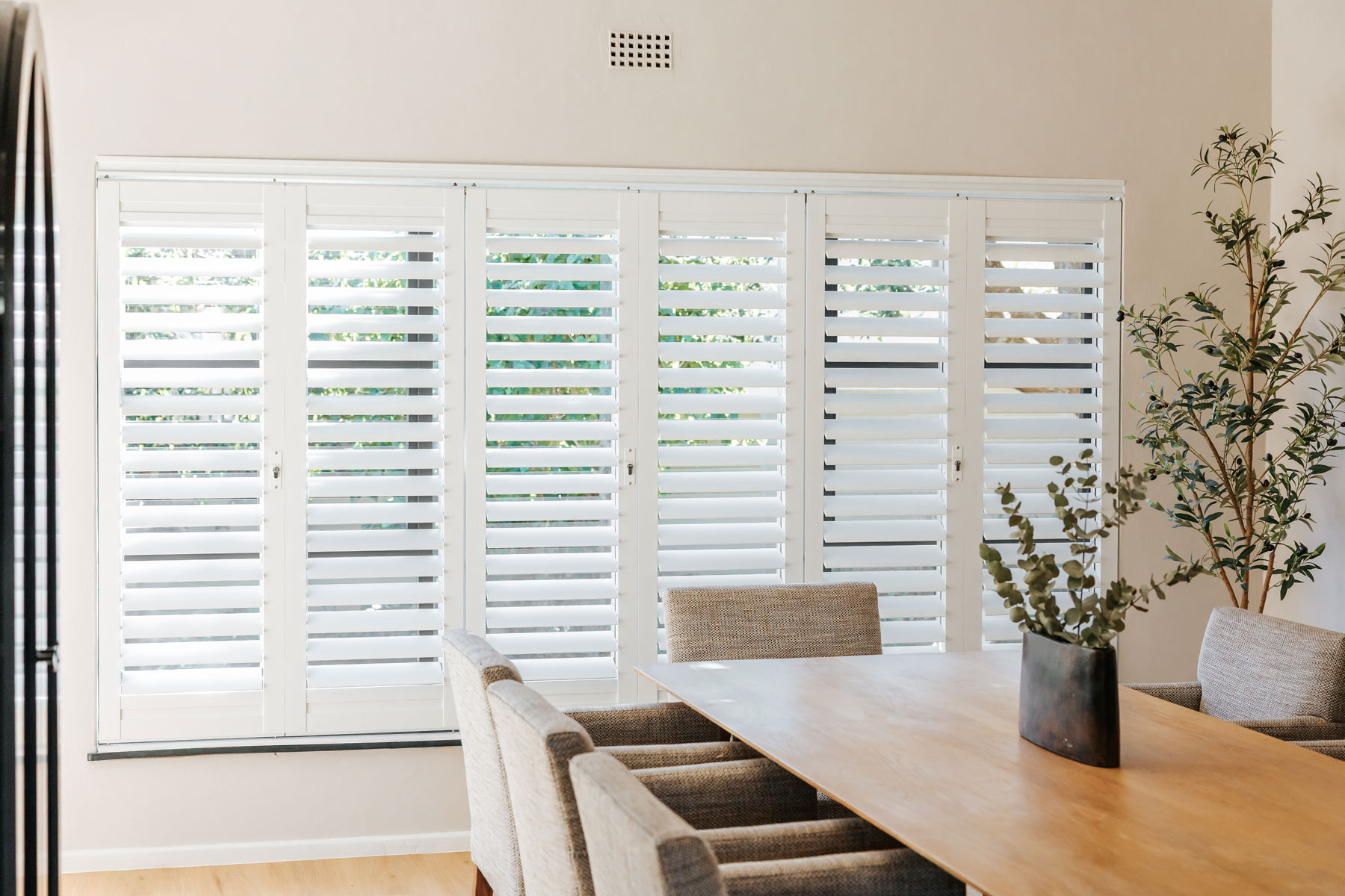 White shutters across a dining room wall